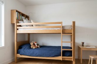 Lit cabane superposé en bois massif dans une chambre d'enfant moderne avec bureau intégré et rangements